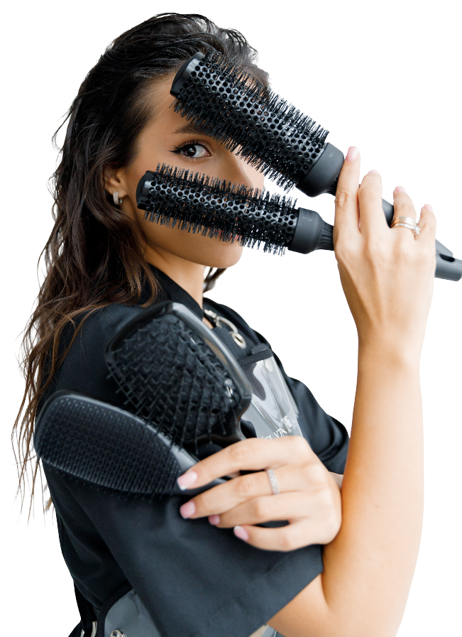 Une coiffeuse avec deux brosses dans les mains