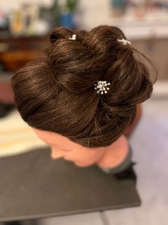 Une coiffeuse avec un sèche-cheveux et une brosse dans les mains