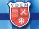 Un logo en forme de bouclier avec l'inscription &laquo; VDEM &raquo; en haut et trois sections rouges contenant un appareil photo, des outils crois&eacute;s et un flocon de neige.