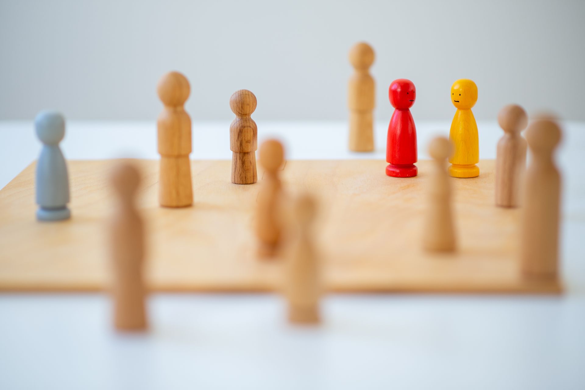 Eine Gruppe von Holzfiguren sitzt auf einem Holzbrett.