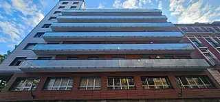 Un edificio alto con muchas ventanas y balcones.