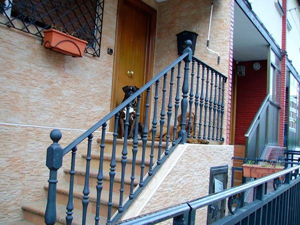 Un perro está sentado en el porche de una casa.