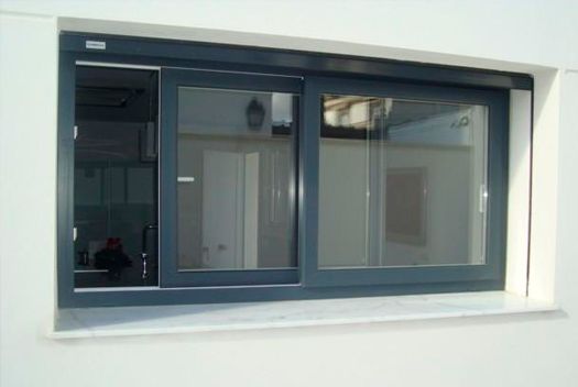 Una ventana con una puerta corrediza de vidrio en una pared blanca.