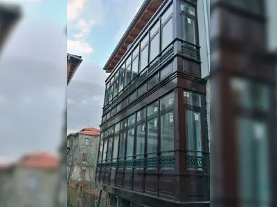 Un edificio grande con muchas ventanas y un balcón.