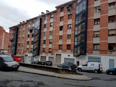 Un montón de coches están aparcados delante de un edificio de ladrillos.