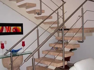 Una escalera con barandilla de acero inoxidable en una sala de estar.