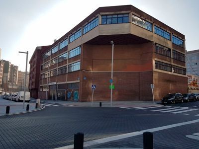 Un gran edificio de ladrillos está situado en la esquina de una calle.