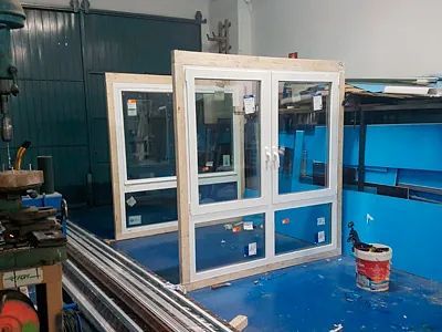 Una habitación con muchas ventanas y un balde de pintura en el suelo.