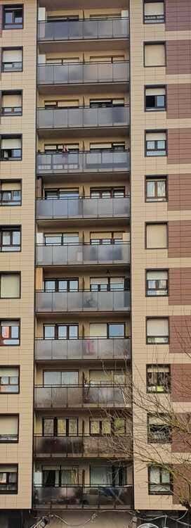 Un edificio alto con muchas ventanas y balcones.