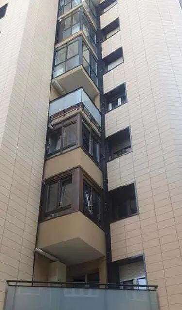 Un edificio alto con muchas ventanas y balcones.