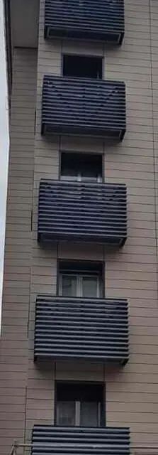 Un edificio alto con muchos balcones y ventanas.