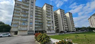 Un gran edificio de apartamentos con coches aparcados delante.