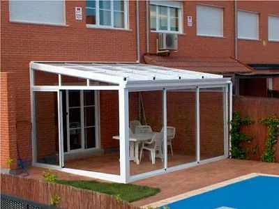 Un patio con mesa y sillas junto a una piscina.