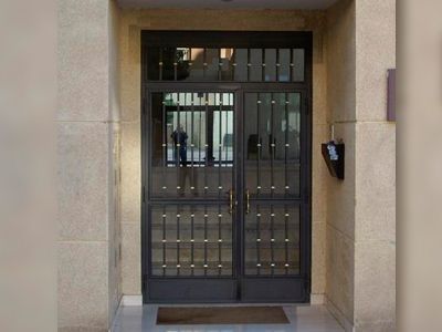 Una puerta con una valla alrededor y un felpudo delante.