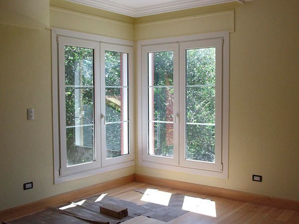 Una habitación con muchas ventanas y paredes amarillas.