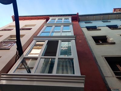 Mirando hacia arriba a un edificio alto con muchas ventanas