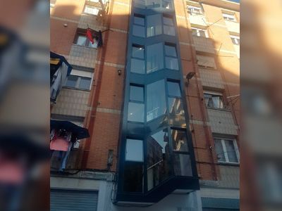 Un edificio muy alto con muchas ventanas y un balcón.