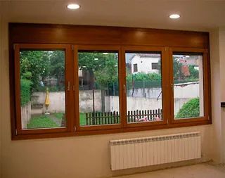 Una habitación con cuatro ventanas y un radiador en el suelo.