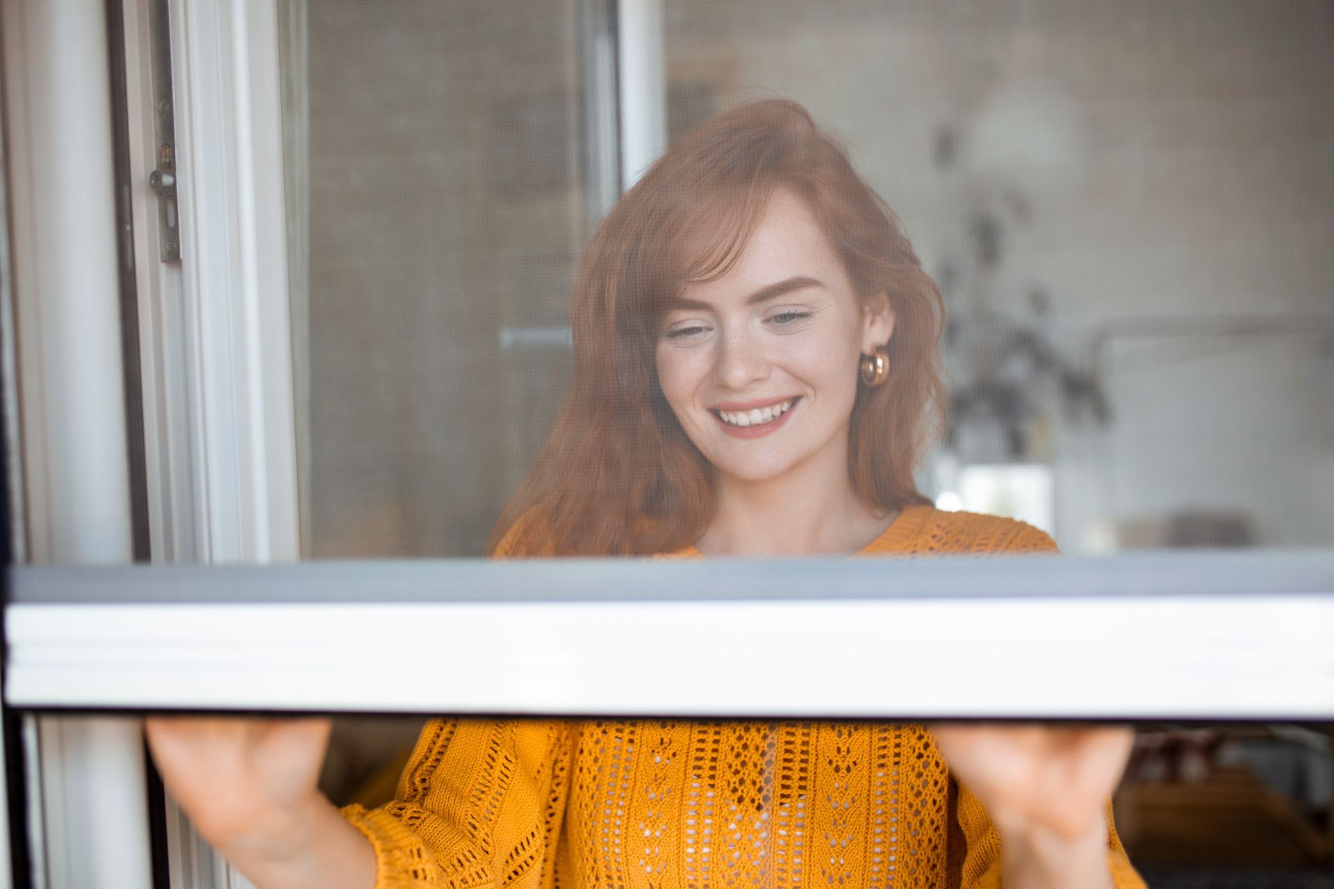 Jeune femme rousse avec un pull orange