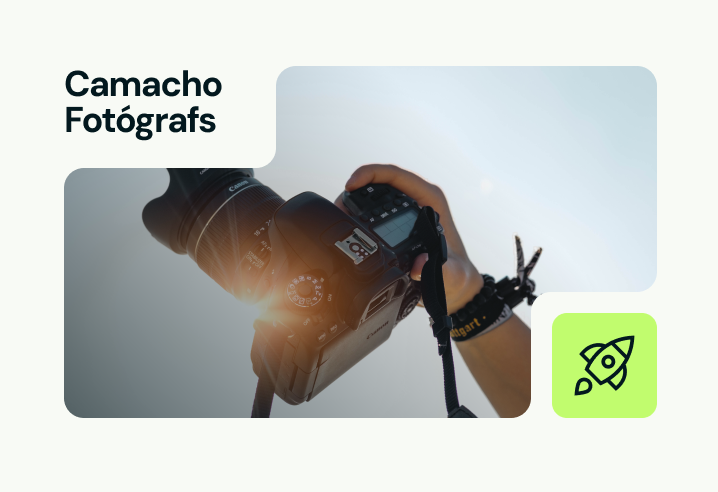 Un fotógrafo sosteniendo una cámara, tomando una fotografía bajo la brillante luz del sol.