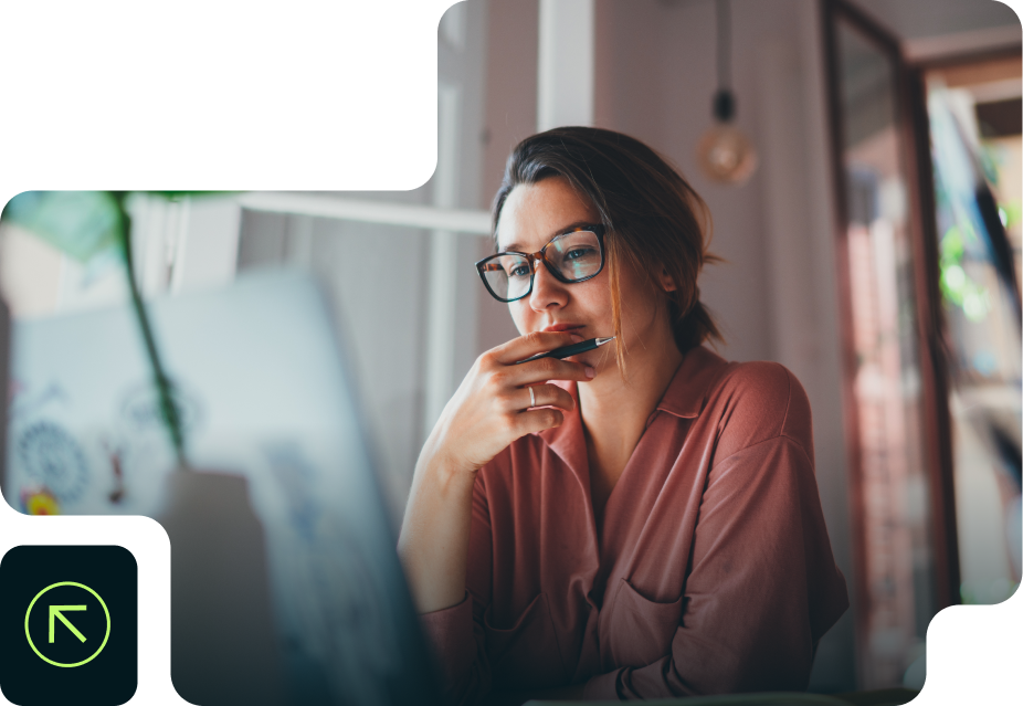 Una mujer con gafas está sentada frente a una computadora portátil.