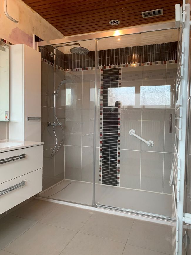 Salle de bains avec cabine de douche et meuble à tiroirs
