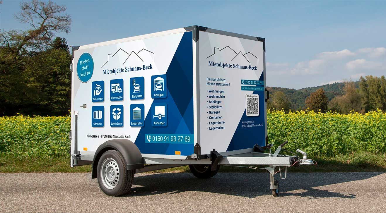 Ein blau-weißer Anhänger steht am Straßenrand.