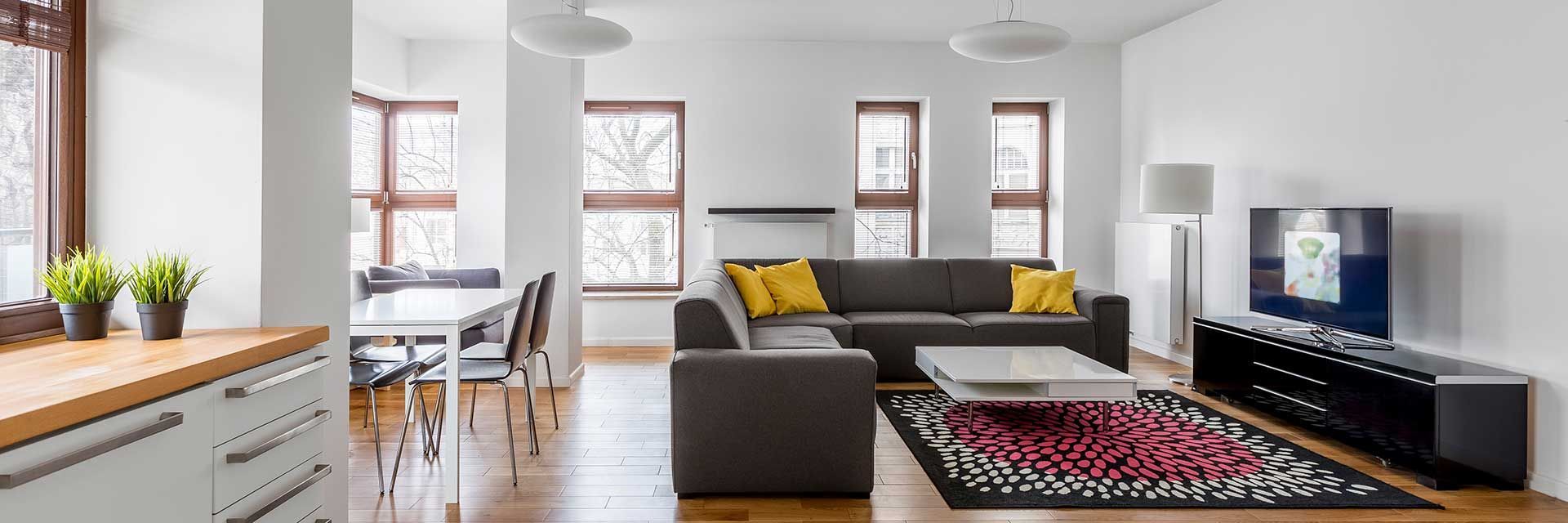 Ein Wohnzimmer mit Couch, Tisch und Fernseher.