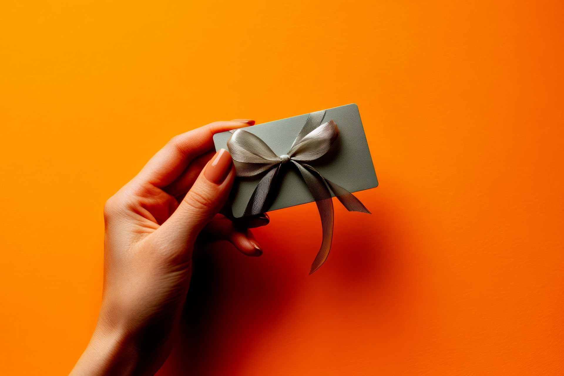 Main qui tient une carte avec un ruban doré