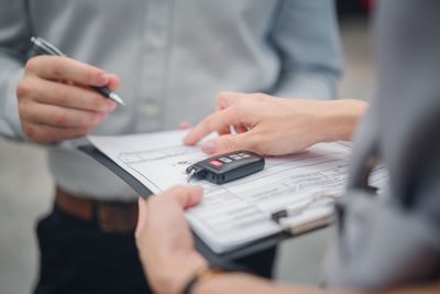 Hands and a calculator over paperwork during a business meeting