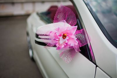 White car side mirror decorated with a pink flower and mesh ribbon bow