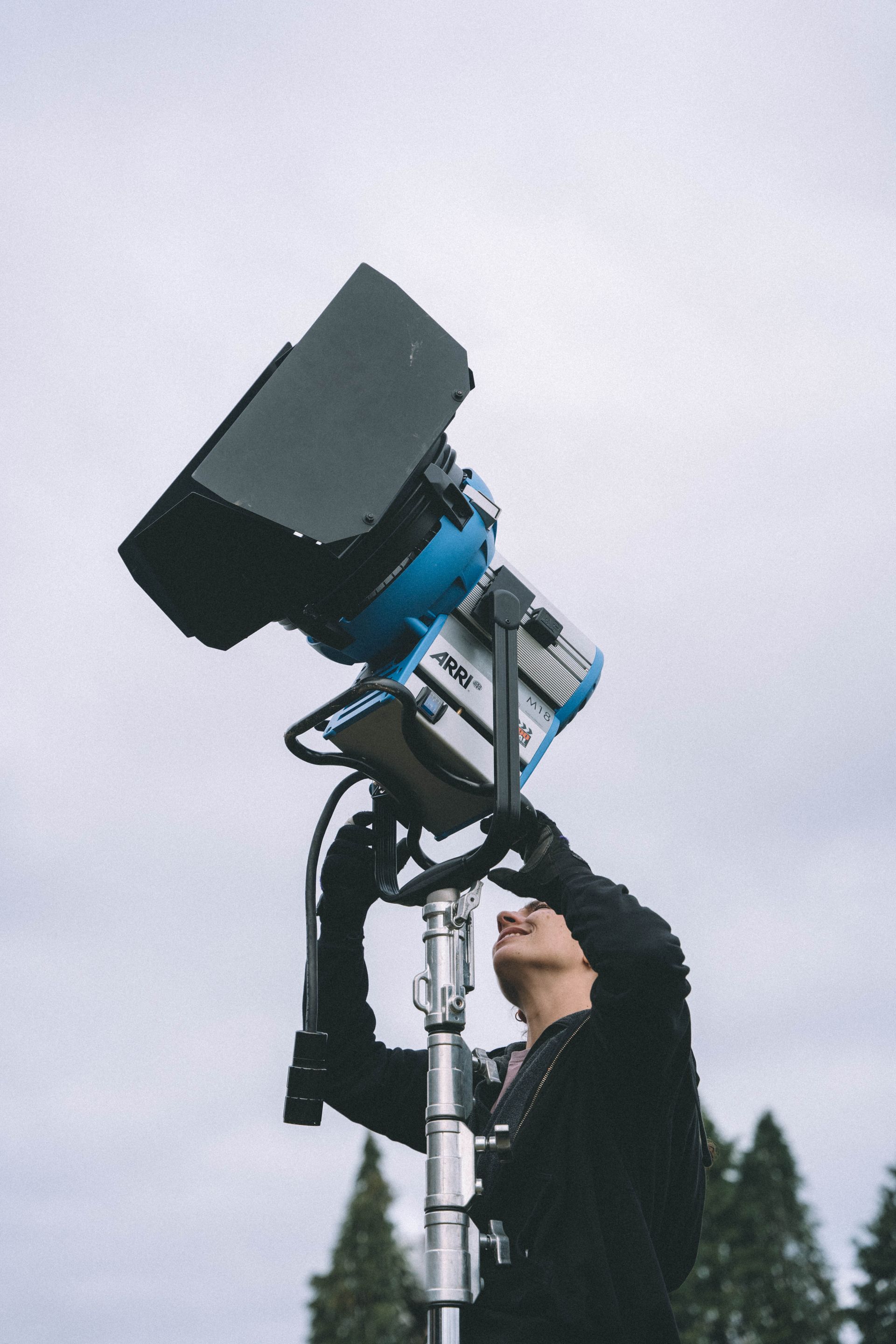 Un hombre mira hacia una luz azul en un poste.