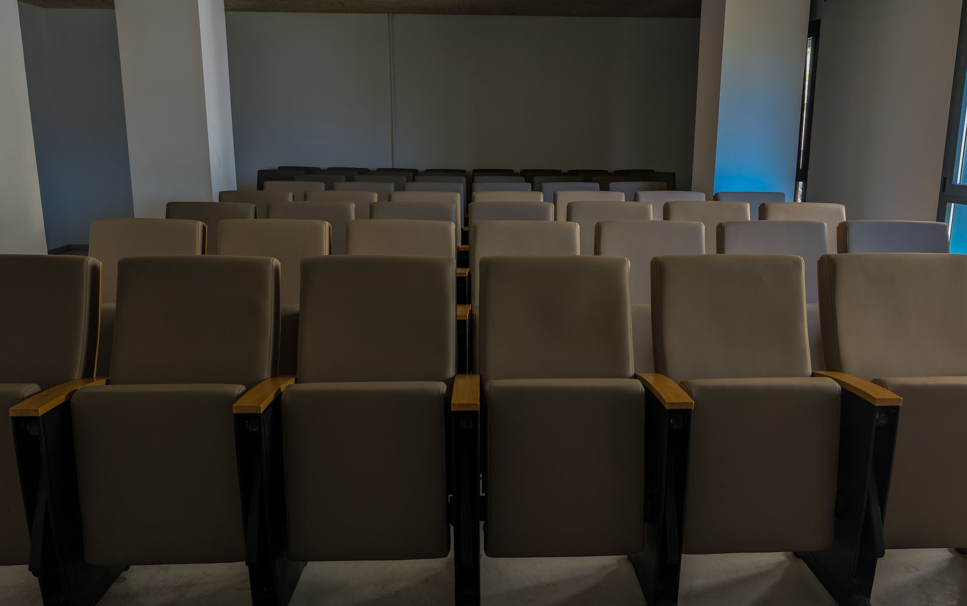 Una fila de sillas vacías en un auditorio oscuro.