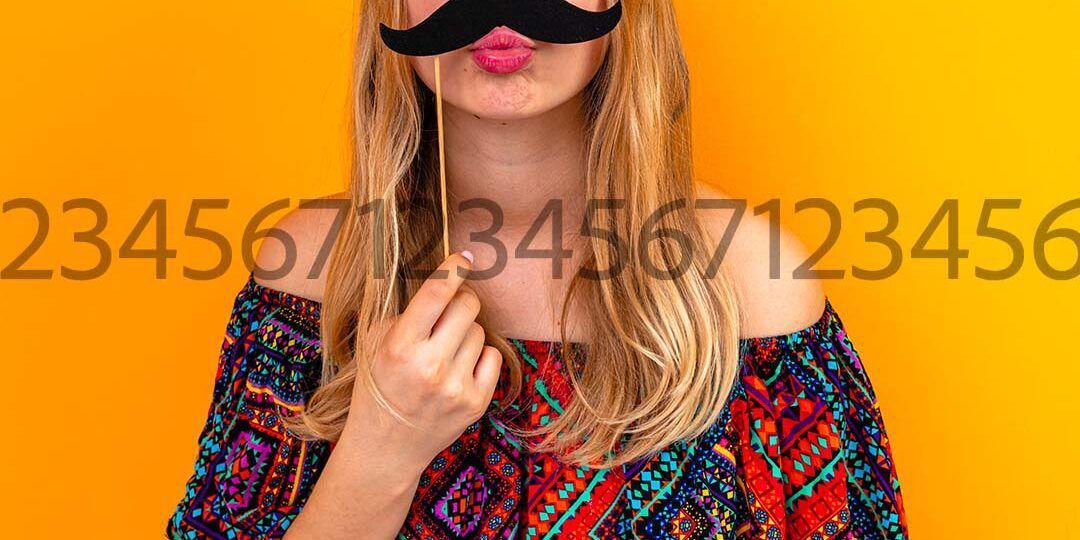 Donna con baffi finti, che lancia un bacio e tiene in mano una piccola ciocca di capelli su uno sfondo arancione.