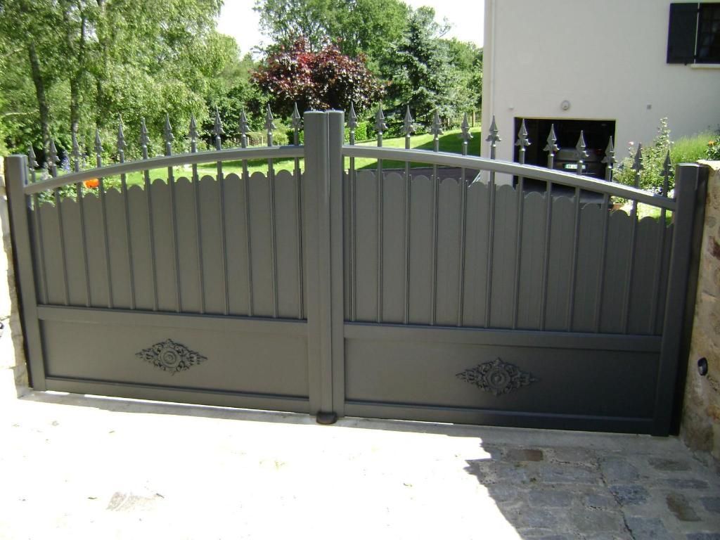 Portail d'allée en métal gris avec partie supérieure et panneaux décoratifs.