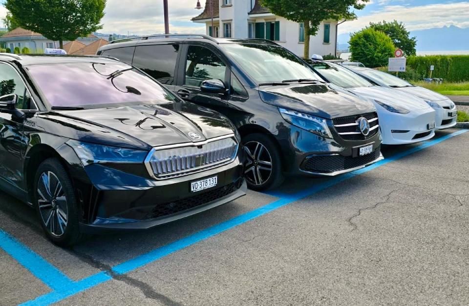Une rangée de voitures est garée dans un parking.