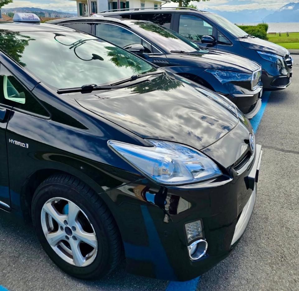 Une rangée de voitures noires est garée dans un parking