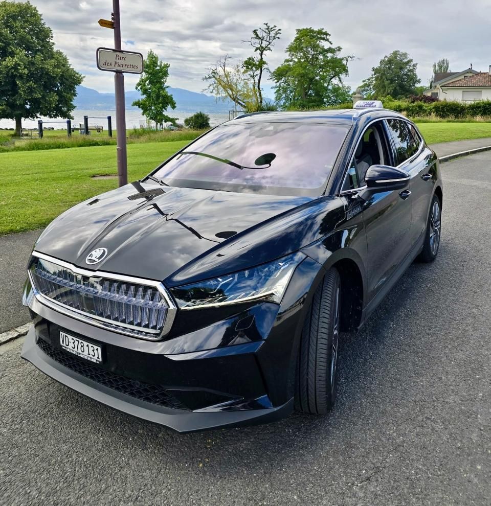 Une voiture noire est garée sur le bord de la route.