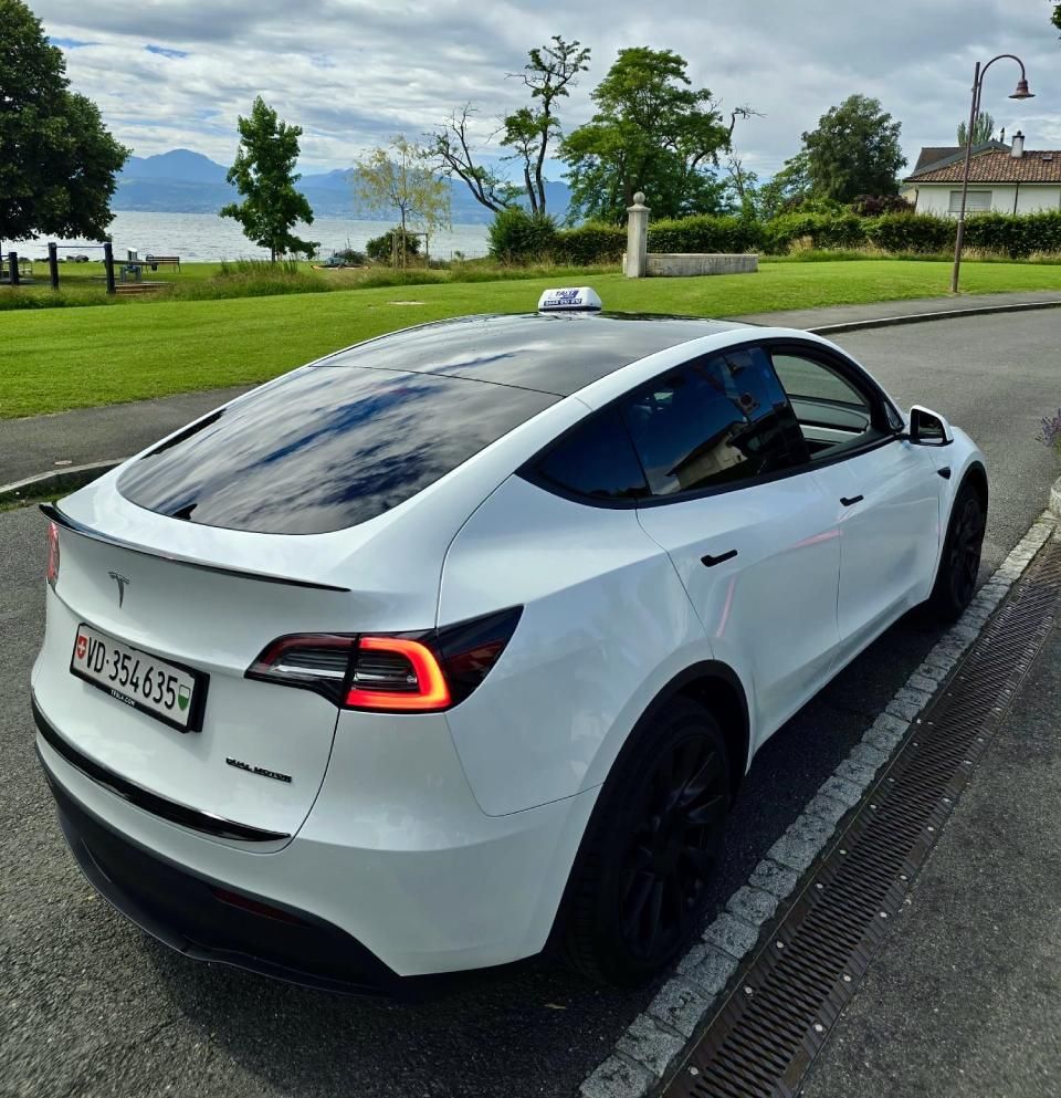 Un modèle tesla y blanc est garé sur le bord de la route