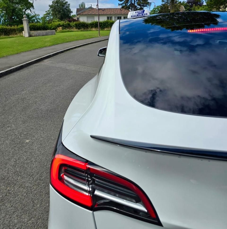 Une voiture blanche est garée sur le bord de la route