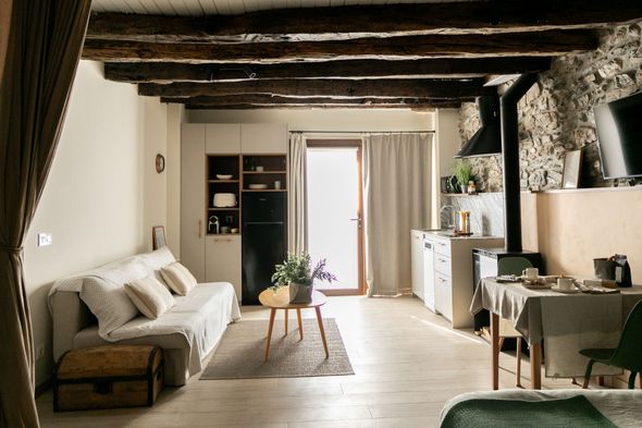 Bañera de hidromasaje con luces azules en un dormitorio, cerca de una cama y vigas de madera.