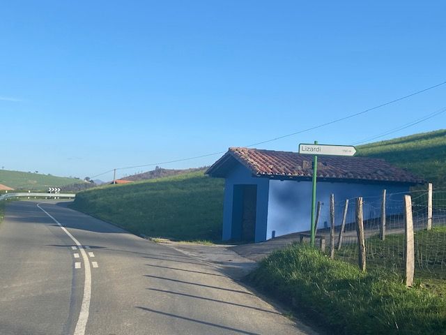 Una carretera con un edificio azul al costado.