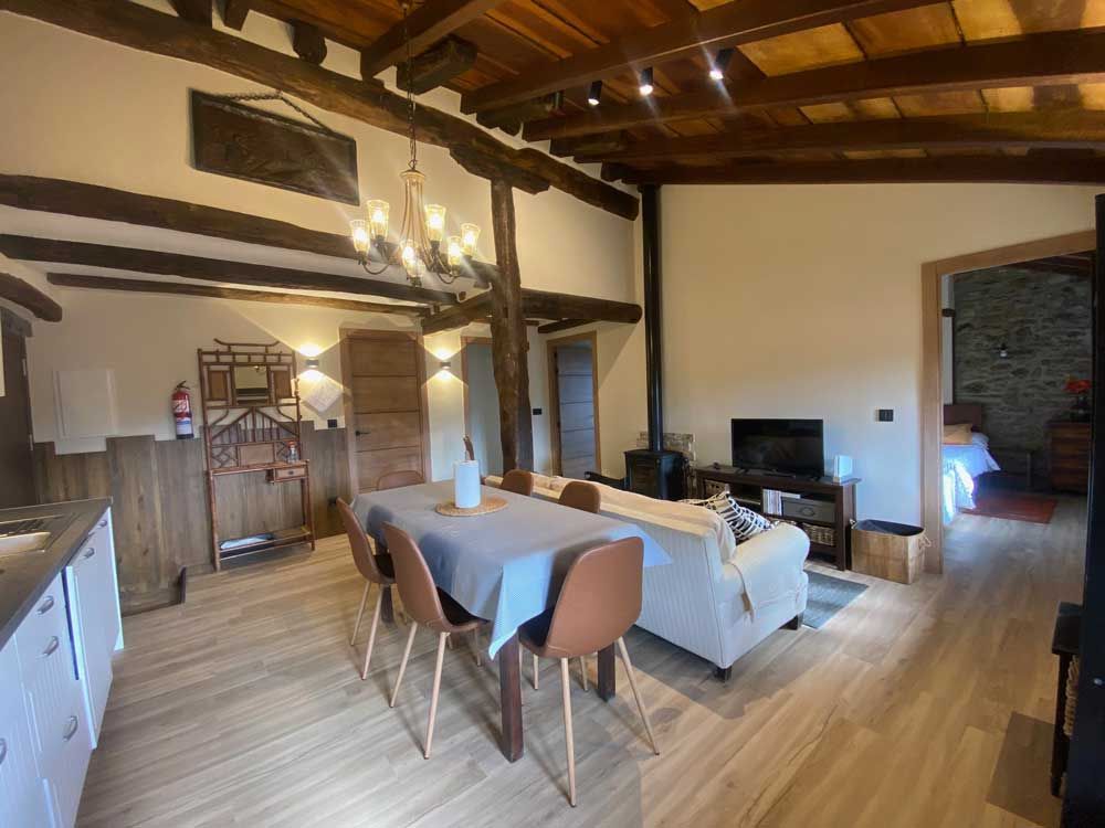 Hay una mesa y sillas en la sala de estar.
