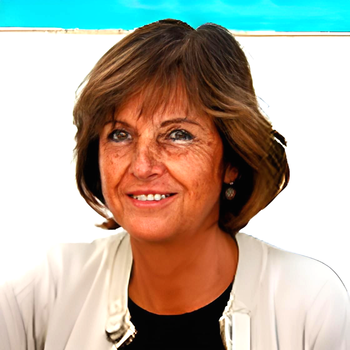 Femme aux cheveux bruns courts, souriante, portant une veste claire sur un haut noir, devant un mur blanc et un fond bleu.