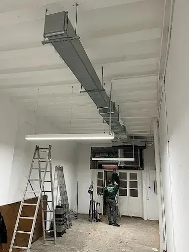 Un hombre está de pie en una habitación con una escalera.