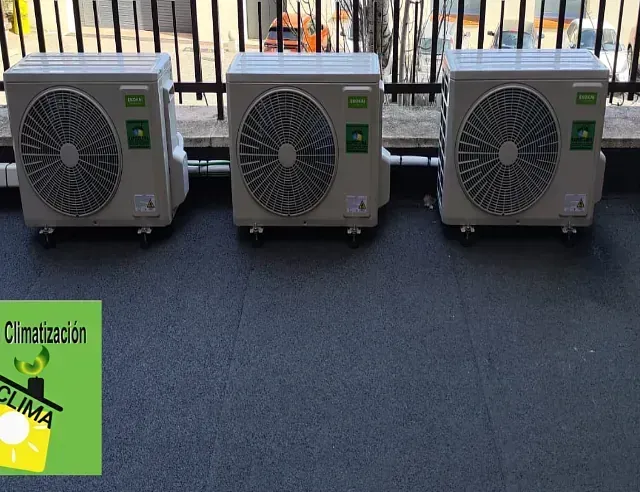 Tres aparatos de aire acondicionado están alineados uno al lado del otro en un balcón.