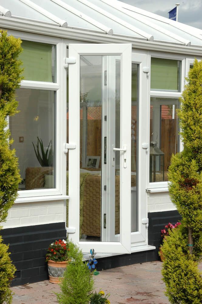 A white door with a glass roof is open to a living room.
