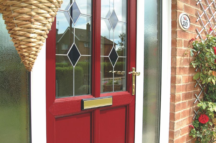 A red front door with a wicker basket hanging from it.