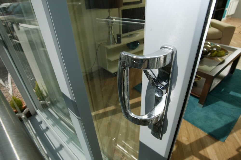 A door with a chrome handle is open to a living room.