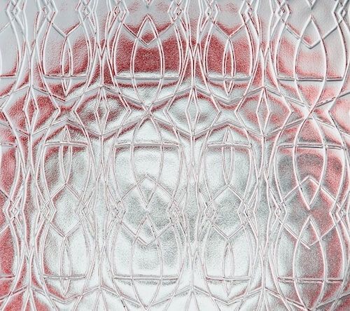A close up of a stained glass window with a red and white pattern.